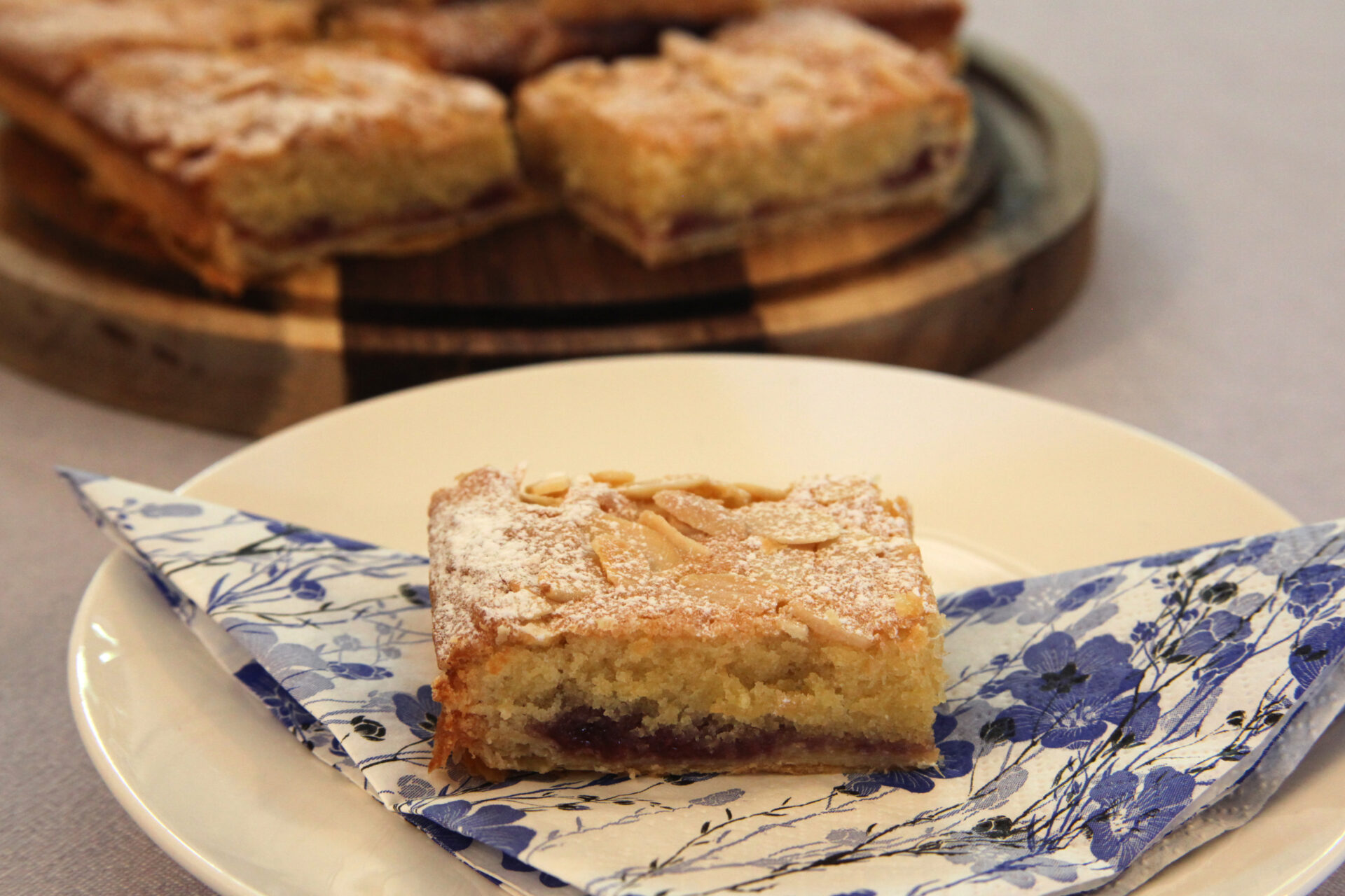 Slice of almond jam cake on floral napkin